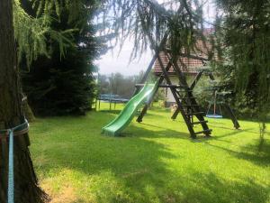 einen Spielplatz mit Rutsche im Gras in der Unterkunft Penzion Harvanek in Vlachovice