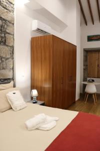 1 dormitorio con 1 cama blanca y armario de madera en Casa da Boa Vista, en Algarvia