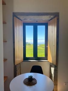 a table and chair in front of a window at Casa da Boa Vista in Algarvia