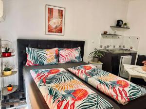 two beds in a living room with colorful pillows at Apartmani Tamara in Tivat