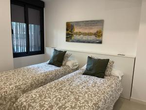 twee bedden naast elkaar in een kamer bij Apartamentos El Olivo in Córdoba