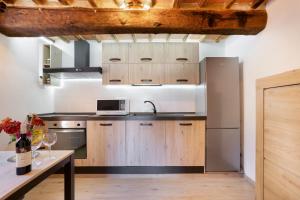 a kitchen with wooden cabinets and a sink and a table at Tower House with emotional shower in Ancaiano