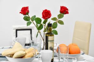 a table with a bottle of wine and roses at Amplio con Parking, Club y Piscina junto a Sevilla in La Algaba