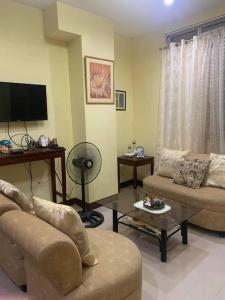 a living room with a couch and a tv at S & E homes 2 in Babuy