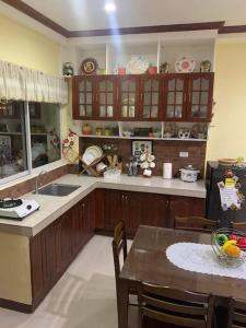 a kitchen with wooden cabinets and a table with a dining room at S & E homes 2 in Babuy
