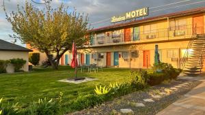 a hotel with a lawn in front of a building at Lakeshore Inn Water Front in Moses Lake