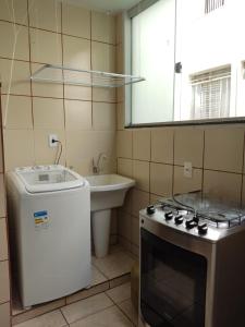 uma pequena cozinha com um fogão e um lavatório em Apartamento 2 quartos Setor Sul em Goiânia