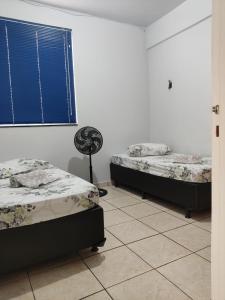 um quarto com duas camas e uma ventoinha em Apartamento 2 quartos Setor Sul em Goiânia