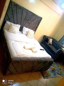 a bedroom with a bed with a headboard and a chair at Attic place South B. in Nairobi