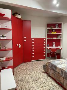 um quarto com armários vermelhos, uma cama e uma secretária em CAPOLINEA em Roccalumera