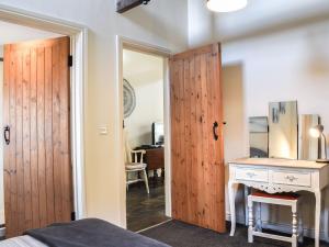una camera da letto con porta in legno che conduce a una scrivania di Guards Cottage a Gleaston