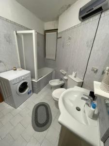uma casa de banho com um lavatório e uma máquina de lavar roupa em CAPOLINEA em Roccalumera