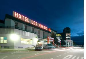 a hotel with cars parked on a street at night at Hotel Abades Loja in Loja