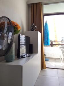 a living room with a tv and a fan on a cabinet at The SunSpot Apartment Playa del Inglés in Maspalomas