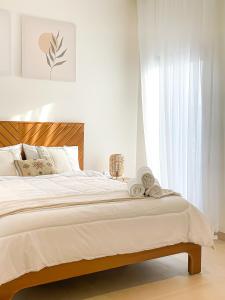1 dormitorio blanco con 1 cama grande con sábanas blancas en Flora chalet, en Ḩifrī