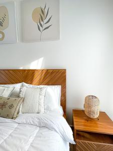 1 dormitorio con cama blanca y cabecero de madera en Flora chalet, en Ḩifrī