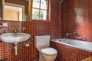 een badkamer met een toilet, een wastafel en een bad bij Tschiffra EG in Bettmeralp
