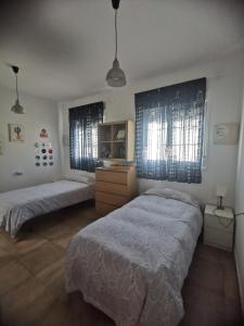 1 dormitorio con 2 camas y 2 ventanas en Botavara, en Cabo de Gata