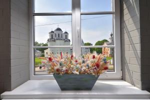 a vase of flowers sitting on a window sill at Rachmaninoff Hotel in Velikiy Novgorod