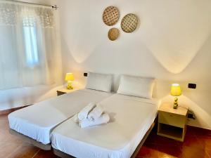 a bedroom with a white bed with towels on it at Porto Antigo 1 - Beach apartments in Santa Maria