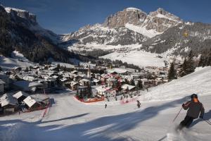 een persoon is aan het skiën in een met sneeuw bedekte berg bij Villa Tony - Small Romantic Hotel in Corvara in Badia