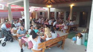 a group of people sitting at tables in a restaurant at Rural Tourism/Ruralni Turizam Kisin in Trebinje