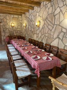 a long table with a red and white checkered table cloth at Rural Tourism/Ruralni Turizam Kisin in Trebinje