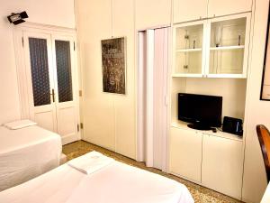 a white room with a bed and a television at Apartment Odesos in Venice