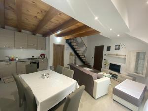 a kitchen and dining room with a white table and chairs at APARTMAN GALERIJA in Ogulin