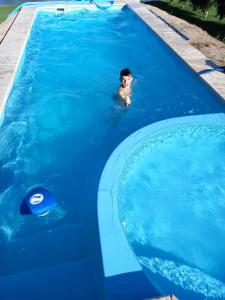 un uomo che nuota in una piscina con un gonfiabile di Relax frente al Lago a Oliveros