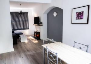 ein Wohnzimmer mit einem Tisch und einem Kamin in der Unterkunft Cozyhouses in Hull