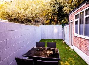 a patio with a table and chairs in a backyard at Cozyhouses in Hull
