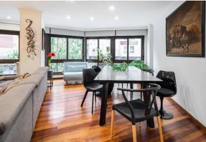 a living room with a table and chairs and a couch at Lujoso y amplio piso con 5 habitaciones in Santiago de Compostela