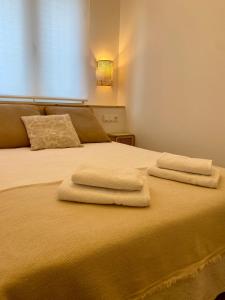 uma cama com duas toalhas em cima em La Espiga de Segovia em La Lastrilla