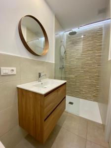 uma casa de banho com um lavatório e um espelho em La Espiga de Segovia em La Lastrilla
