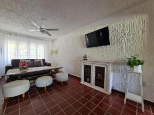 sala de estar con sofá y TV en la pared en CASA TREBOL disponible ExpoAgro en San Pedro