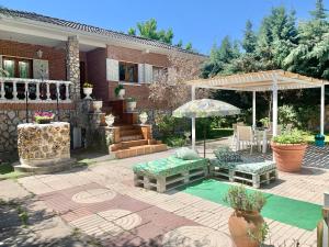 Casa con patio con mesa y sombrilla en Casa Rural Serafïn, Pet Friendly, en Renera