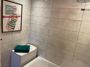 łazienka z toaletą z plakatem na ścianie w obiekcie Apartament Karlikowska z widokiem na morze w mieście Sopot