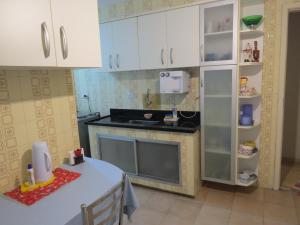 eine Küche mit weißen Schränken und einer Arbeitsplatte in der Unterkunft Quarto Aconchegante in Rio de Janeiro