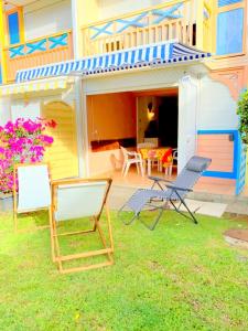 una casa colorata con sedie e patio di Color Garden - Studio Martinique a Sainte-Anne