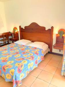 una camera da letto con un letto con copriletto floreale di Color Garden - Studio Martinique a Sainte-Anne