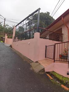 Casa con pared de color rosa y balcón en Casa entre la naturaleza, en San Marcos