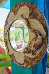 a mirror with a snake on a blue pole at La Maison Créole, les gîtes titanse, 3 chambres. in Cadet