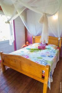 a bedroom with a wooden bed with a canopy at La Maison Créole, les gîtes titanse, 3 chambres. in Cadet