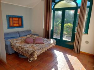 オメーニャにあるLuci dal Lagoのベッドルーム1室(ベッド1台、ソファ、窓付)