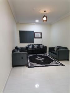 a living room with couches and a flat screen tv at Al Basam Furnished Units in Yanbu