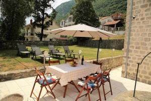 a table and chairs with an umbrella on a patio at Villa Captain in Kotor
