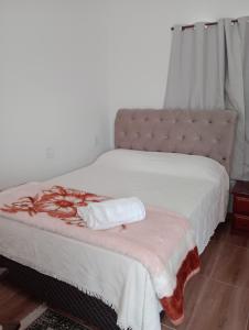 Un dormitorio con una cama con una manta. en Recanto das Videiras en Maria da Fé