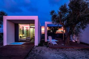 una casa rosa con terrazza e albero di Terecate Experimental Relais a Melendugno
