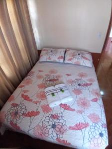 a bed with a floral bedspread and two pillows on it at Casa entre la naturaleza in San Marcos